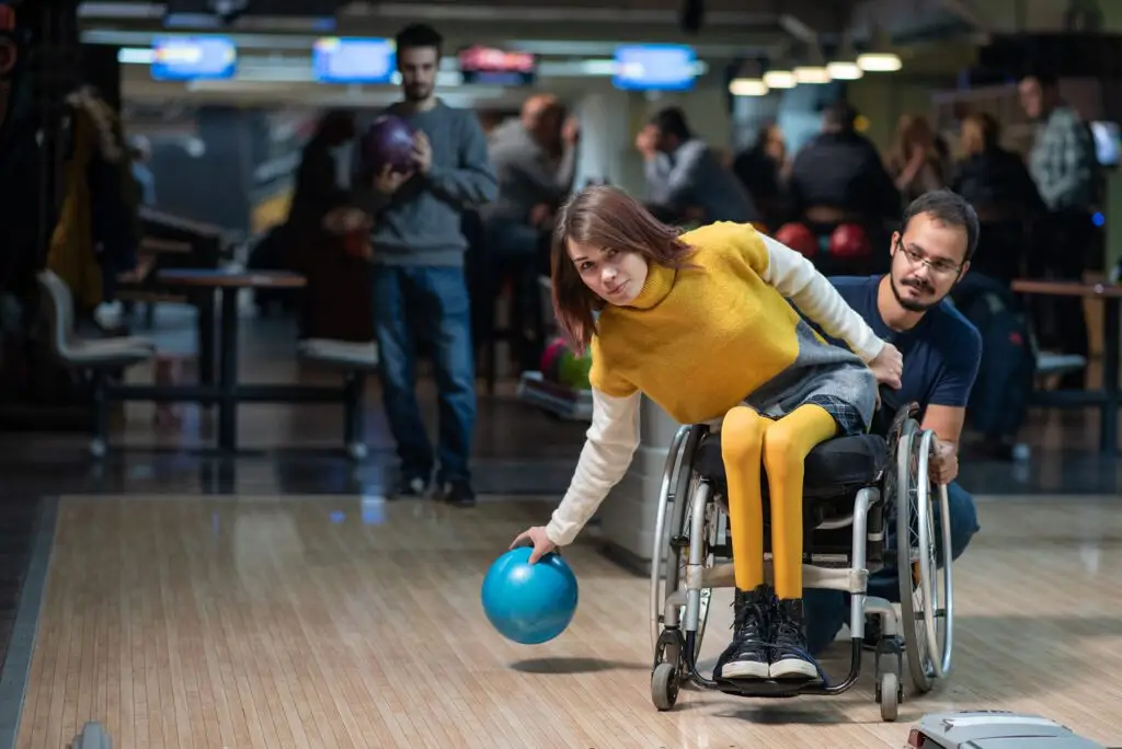 Person in a wheelchair bowling with friends, showing accessible play