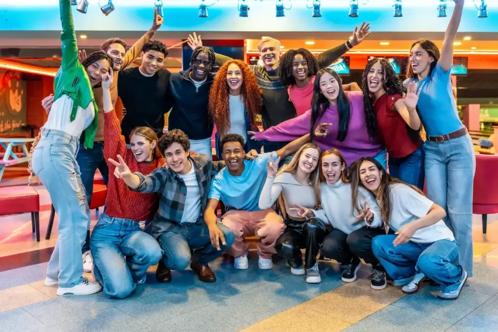 Large group of friends smiling and posing together at the bowling alley