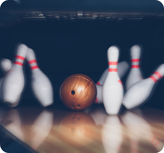 Bowling ball hitting pins in a blue-lit lane