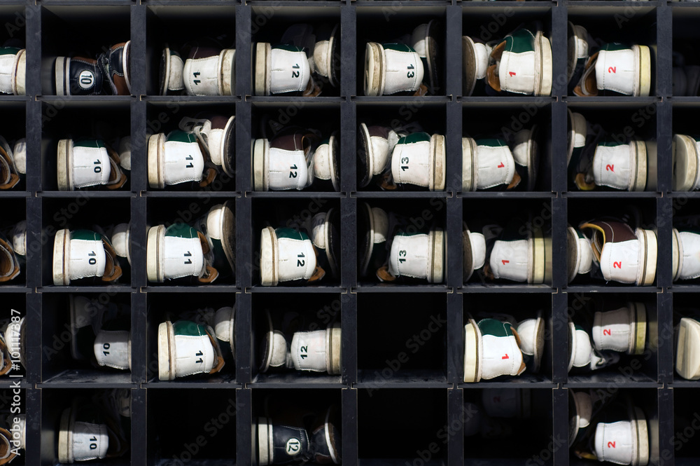 Rows of rental bowling shoes arranged on shelves at the venue