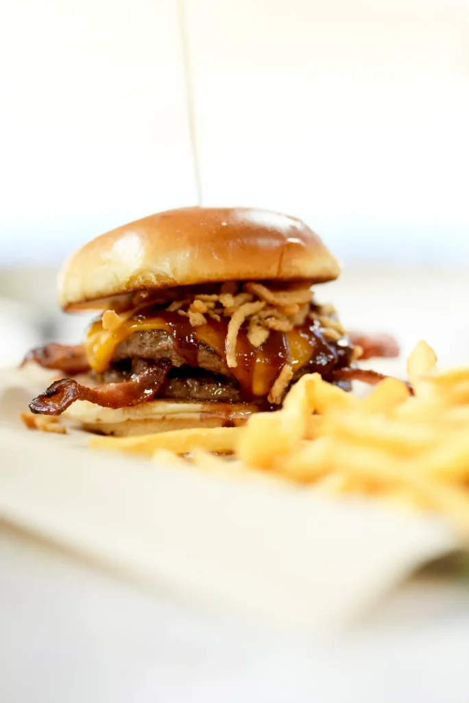 Double-stacked burger loaded with bacon, mushrooms, swiss cheese, and onion straws served with golden fries